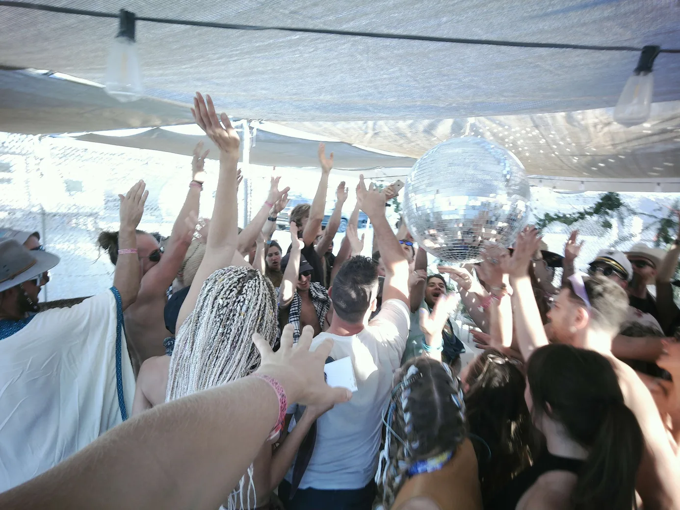 A crowd dancing under a disco ball at Muse Cafe
