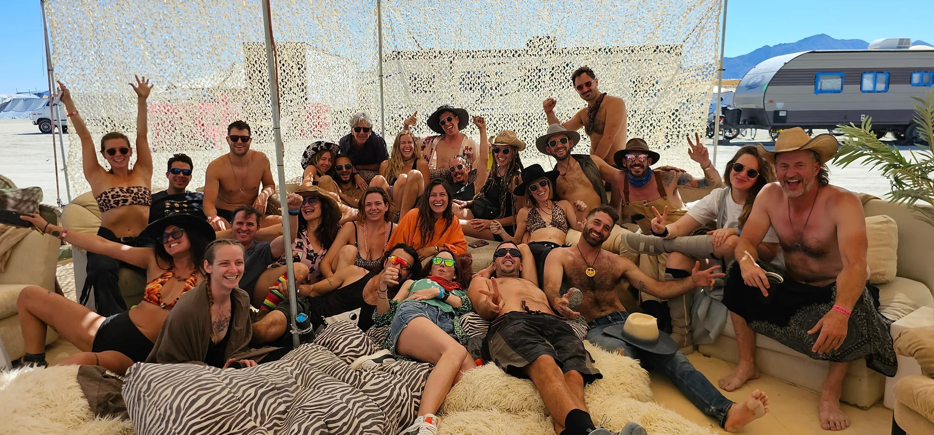The whole Muse crew smiling together under the shade net